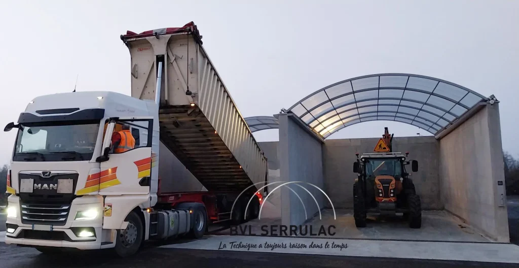 Livraison et déchargement par un camion rempli de sel dans une case de stockage abritée par un abri industriel aluminium